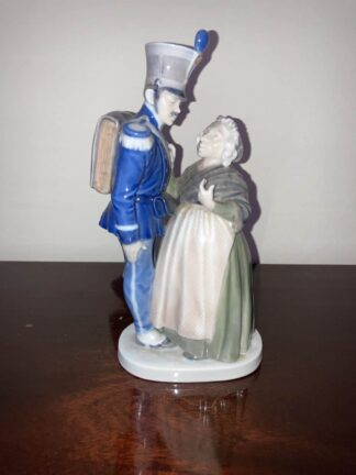A smartly dressed Soldier, with feathered hat and backpack, talks up close to a motherly looking Witch