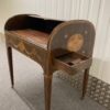 Side view of desk with tambour partially open and writing pad laying flat, draw also open